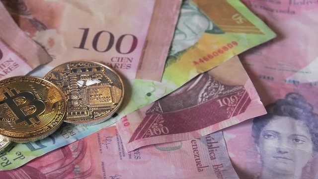 Physical metal Bitcoin currency over bolivar bills. Virtual internet money with Venezuelan banknotes. Digital coin cyberspace, cryptocurrency. BTC golden coin as symbol of electronic virtual money. 4K