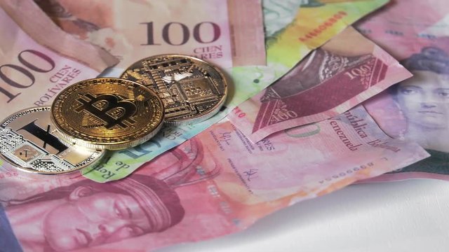 Physical metal Bitcoin currency over bolivar bills. Virtual internet money with Venezuelan banknotes. Digital coin cyberspace, cryptocurrency. BTC golden coin as symbol of electronic virtual money. 4K