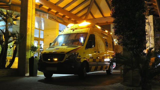 Ambulance with Flashing Siren Lights Parked By Emergency Department