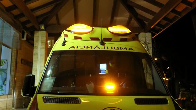 Ambulance with Flashing Siren Lights Parked By Emergency Department