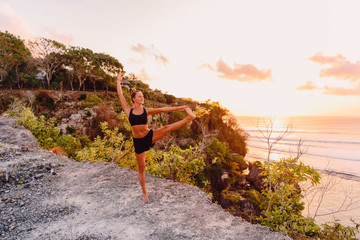 Yoga woman practicing yoga at sunset time