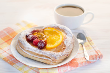 puff  cake  decorate with different fruit with cup of coffee on white table