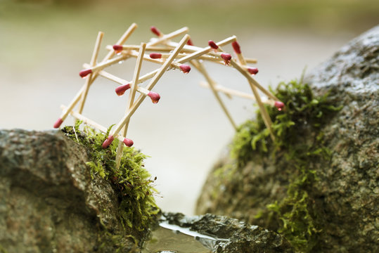 Fototapeta self-supporting bridge by leonardo da vinci built from matches over mossy rocks