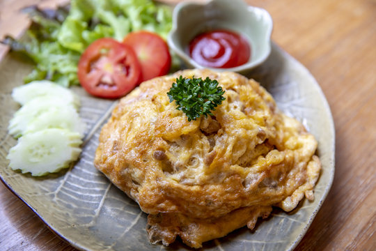 Thai omelette with rice on table