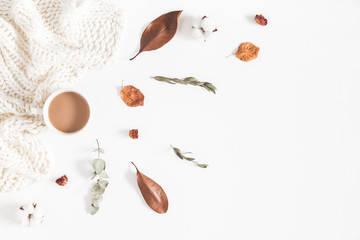 Autumn or winter composition. Cup of coffee, dried autumn leaves, knitted blanket on white background. Flat lay, top view