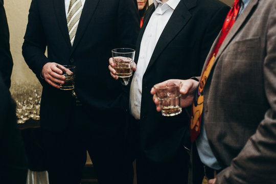 Handsome Stylish Man With Alcohol Drink Posing At Business Dinner Party, Corporate Suit Man Holding Glass In Hands At Restaurant Reception, Wedding Concept