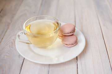 Tasty pink macaroons on a wooden table. It can be used as a background