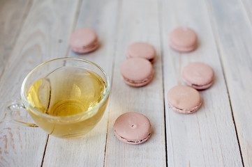 Tasty pink macaroons on a wooden table. It can be used as a background