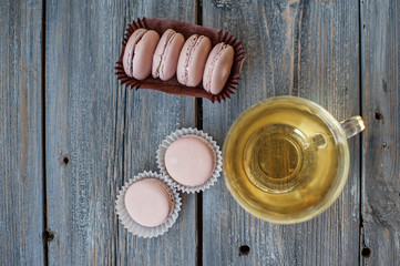Tasty pink macaroons on a wooden table. It can be used as a background