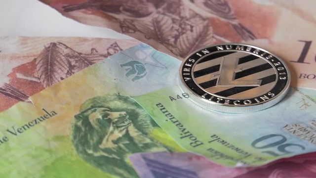 Physical metal Bitcoin currency over bolivar bills. Virtual internet money with Venezuelan banknotes. Digital coin cyberspace, cryptocurrency. BTC golden coin as symbol of electronic virtual money. 4K
