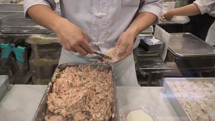 Blurry image of Man or chef is making dim sum. by dumpling wrappers.