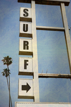 aged and worn vintage surf sign with palm trees