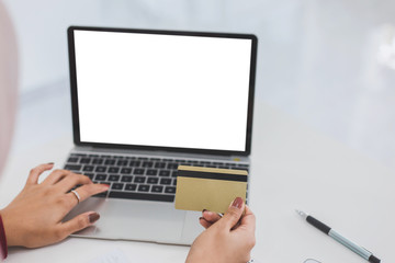 Young woman holding credit card and using laptop and computer for online shopping