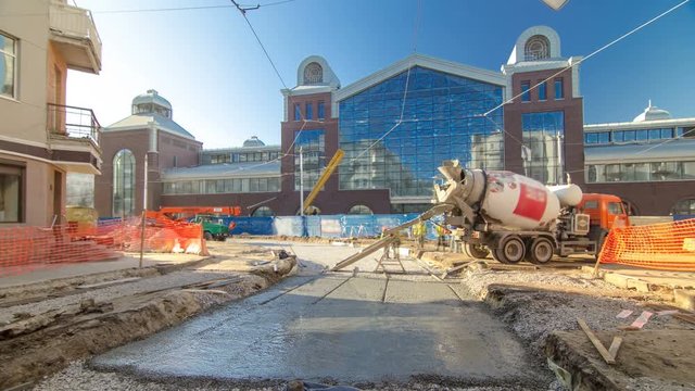 Concrete works for road maintenance construction with many workers and mixer timelapse