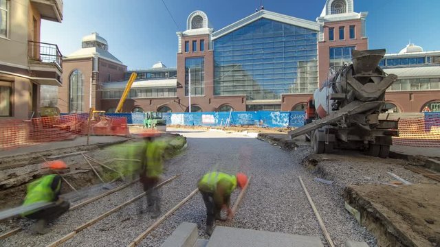 Concrete works for road maintenance construction with many workers and mixer timelapse