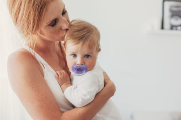 Young mom kissing her 8 month baby