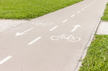 Obraz premium bicye lane with signs on asphalt in park