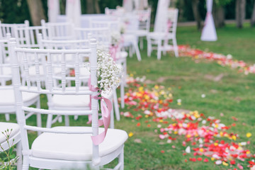 Fototapeta na wymiar wedding or ceremony set up in garden, white chairs
