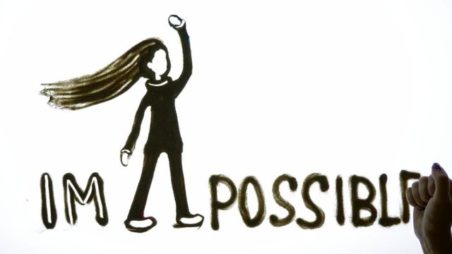 motivational message, Sand Artist writes an inspirational phrase im possible on brightly lit screen