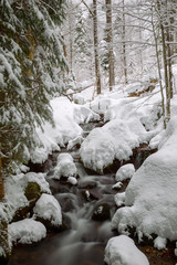 Langzeitbelichtung eines Bachs im verschneiten Bayrischen Wald, Bayern, Deutschland.