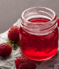 Raspberry jam in a jar with fresh raspberries. Copy space