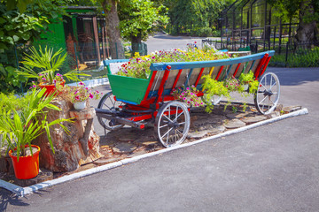 Fototapeta na wymiar Decorative wooden cart filled with flowers