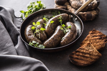 Roasted sausages in pan with bread and herbs.
