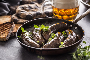 Roasted sausages in pan with bread herbs and draft beer.