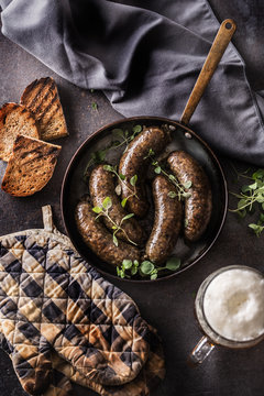 Roasted sausages in pan with bread herbs and draft beer.