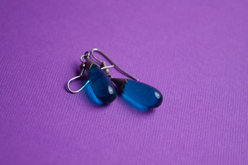 silver earrings with a blue stone on a purple background