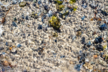 Sandy Beach with colorful rocks covered by water