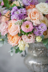 Gorgeous bouquet of different flowers. floral arrangement in vintage metal vase. table setting....