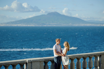 Fototapeta na wymiar Young romantic couple on a background of a sea landscape and Vesuvius, Naples, Italy