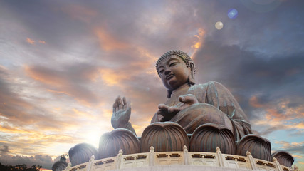 Tian Tan Buddha with sun flare and twilight sunset background located at Ngong Ping, Lantau Island, in Hong Kong