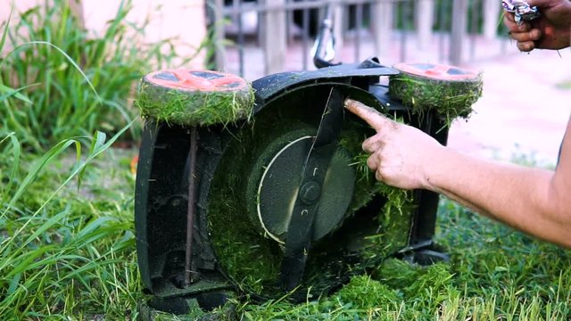 The worker cleans the mower trimmer