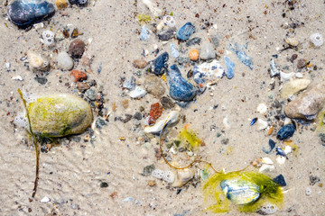 Sandy Beach with colorful rocks covered by water