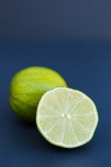 Fototapeta na wymiar One sliced lime on the dark background