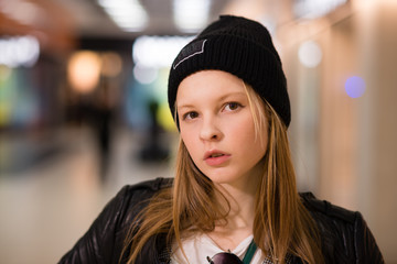 the girl in sunglasses and a black hat in a purple jumpsuit and a black leather jacket 