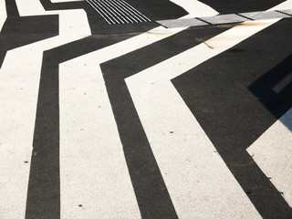 black and white striped pattern on a street near a railway station