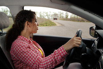 Portrait of happy young african american woman driving a car and smiling