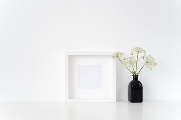 Elegant white square frame mock up with a herbal Gerard in black vase on white background. Mockup for quote, promotion, headline, design. poster for small businesses, lifestyle bloggers, social media