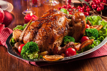 Baked or roasted whole chicken on Christmas table
