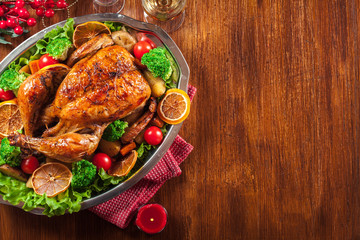 Baked or roasted whole chicken on Christmas table