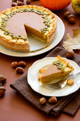 Homemade pumpkin pie with cinnamon on brown paper background. Thanksgiving day or Halloween holiday concept