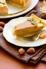 Homemade pumpkin pie with cinnamon on brown paper background. Thanksgiving day or Halloween holiday concept