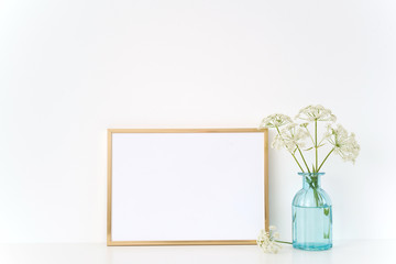 Gold portrait frame mock up with a herb gerard in vase. Mockup for quote, promotion, headline, lettering. Template for small businesses, lifestyle bloggers, social media