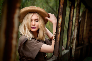 girl in a khaki dress in a safari style and hat near old bus in jungle © pavlobaliukh