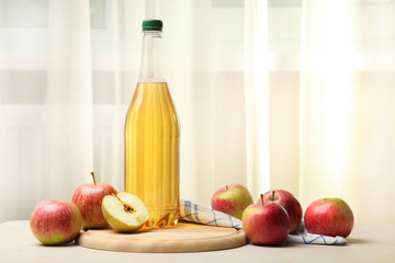 Apple cider in a bottle on the window background.