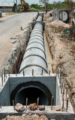 Culvert cement drainage pipe row on the construction site near the road.