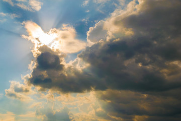 Fototapeta premium bright sun illuminating the clouds from behind with light rays